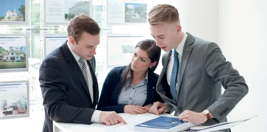 Team members with documents outdoors